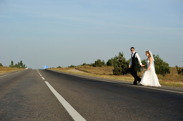 Wall Mural - A Just Married Couple Crossing a Paved Road