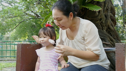 Wall Mural - Asian Mother and child eating icecream together 