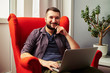 © ArtFamily - man sitting in the red chair with laptop