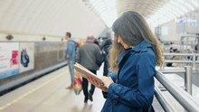 Young Woman Reading A Book In Subway Platform