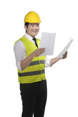 Wall Mural - Asian worker wearing safety vest and yellow helmet holding blueprint