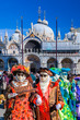 Venice with carnival masks against Mark's Square in Italy