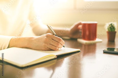 Fotomural Female hands writing on notebook