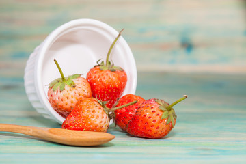 strawberries in bowl on wood background