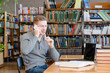 © Ermolaev Alexandr - Boy in library talking on the phone