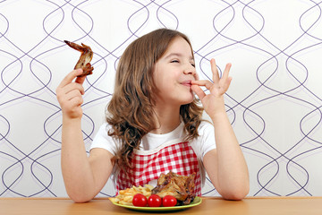 Wall Mural - happy little girl with chicken wings and ok hand sign