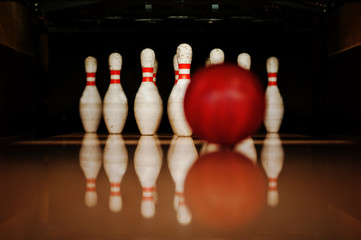 Ten white pins in a bowling alley with ball hit