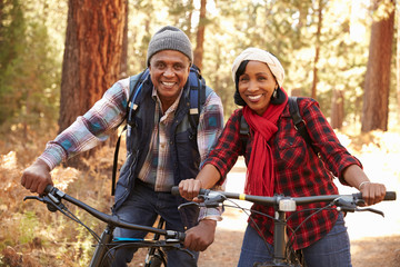 Wall Mural - Portrait Of Senior Couple Cycling In Fall Woodland