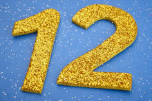 Number Twelve Yellow Color Over A Blue Background. Anniversary