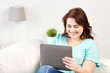 © Syda Productions - happy young plus size woman with tablet pc at home