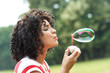 © Zoran Zeremski - Portrait of beautiful woman blowing bubbles in park.