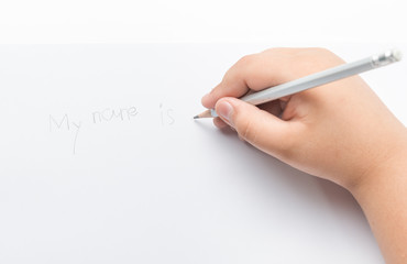 Young boy write his name by pencil.