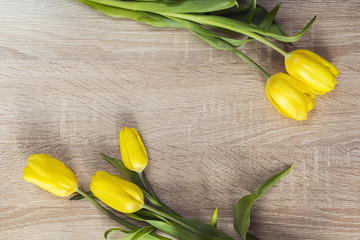 Five yellow tulips on a wooden background and empty space for te