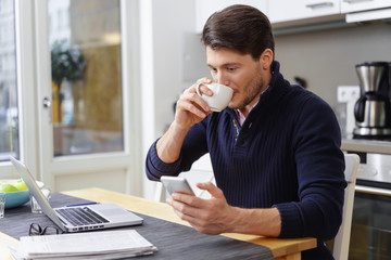 Canvas Print - mann trinkt einen kaffee und schaut auf sein handy