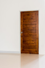 Wooden door set in a white wall