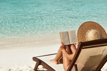 Young Woman Reading A Book At Beach
