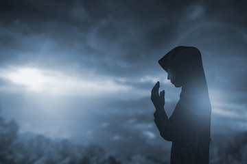 Wall Mural - Catholic Nun in Worship: Outstretched Arms in Sunlight, Praying with Faith and Spiritual Belief, Embracing the Cross and Resurrection Under an Orange Light and Clouded Skies, Reflecting Divine.