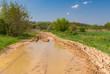 Spring landscape with big puddle on an earth road