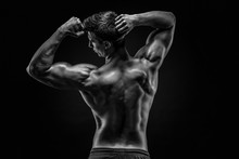 Healthy Muscular Young Man Showing Back And Biceps Muscles