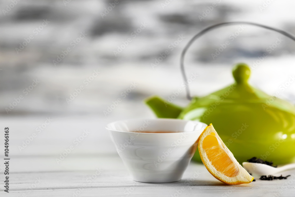 Glass cup of green tea with lemon on blurred background