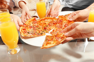 Wall Mural - Friends hands holding hot pizza, close up