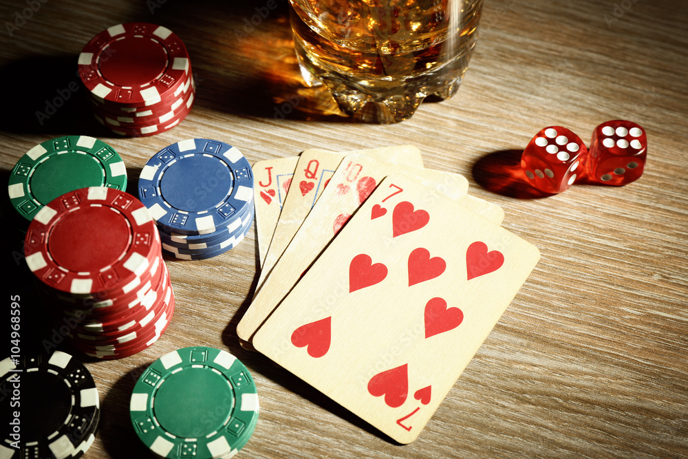 Set to playing poker with cards and chips on wooden table, top view
