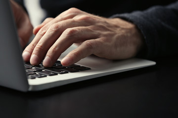 Canvas Print - Male hands typing on laptop keyboard at table closeup