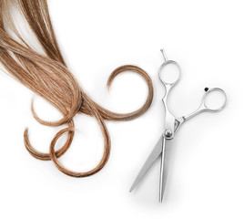 Wall Mural - Hairdresser's scissors with strand of brown hair, isolated on white