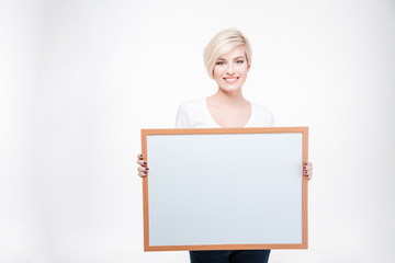 Happy blonde woman holding blank board