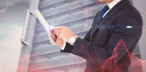 Canvas Print - Composite image of businessman in suit using digital tablet