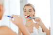 © Syda Productions - woman with toothbrush cleaning teeth at bathroom