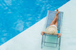 © Netfalls - woman enjoying on sunbed at swimming pool