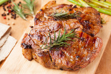 Pork Chop With Rosemary On Wooden Board