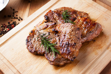 grilled pork chop with rosemary on wooden board