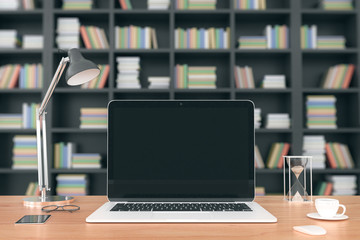 Poster - Blank laptop screen on wooden table at bookshelf background, moc