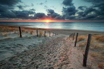 sand path to North sea beach at sunset