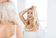 © Syda Productions - happy young woman looking to mirror at bathroom