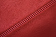 Red leather background with sewing seam