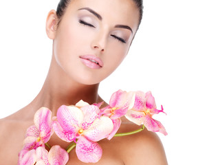 Wall Mural - Beautiful face of  woman with healthy skin and pink flowers