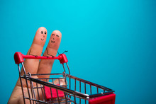 Funny Fingers Shopping At Supermarket With Red Cart Trolley On Blue Background
