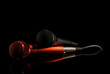 Two microphones lying on black surface. Black background, close up