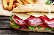 Sandwich with lettuce, slices fresh tomatoes, salami, hum and cheese