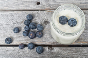 homemade natural yogurt with blueberries fruits on a wooden tabl