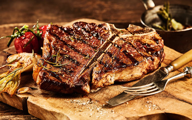 Succulent grilled t bone steak with fork and knife