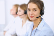 © rogerphoto - Call center. Focus on beautiful woman in headset