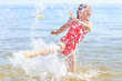 © Voyagerix - Little girl kid splashing in sea ocean water. Fun