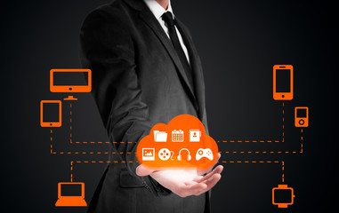 Businessman holding a cloud connected to many objects on a virtual screen concept about the internet of things