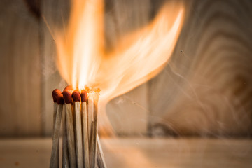 group of match is ignite on a blurry wood background. Selective