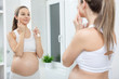 Pregnant woman in bathroom mirror