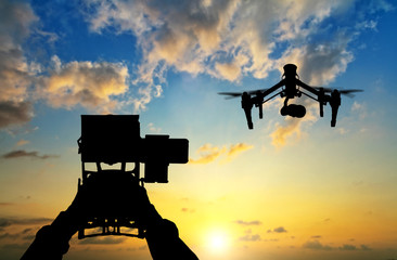 Wall Mural - man hands handling drone in sunset silhouettes